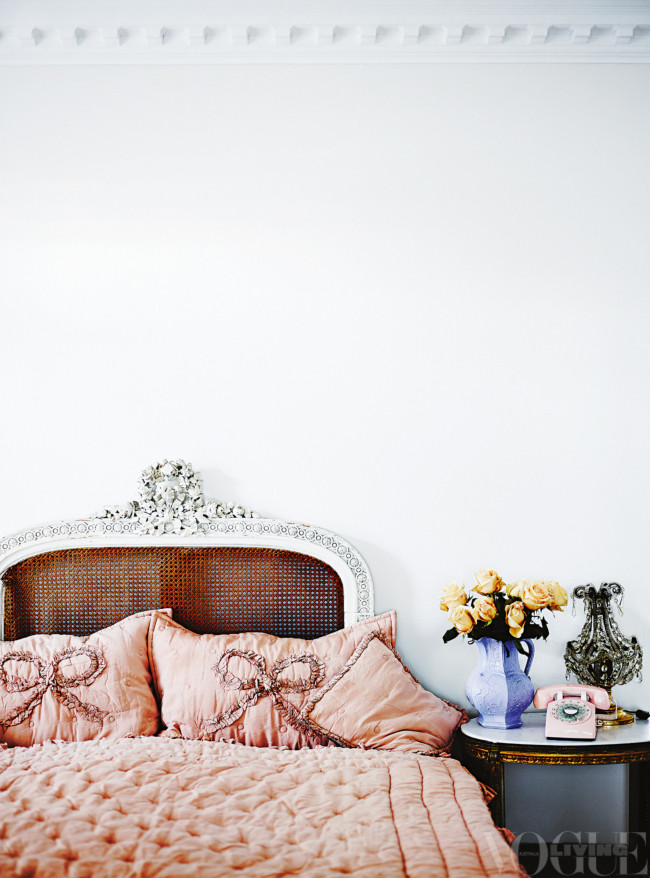 Dormitorio con cabecero de anea, cojines y cubrecama rosa